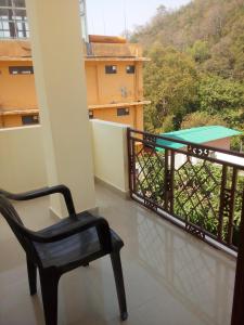 een stoel en een tafel op een balkon met uitzicht bij Shiva Homestay in Rishīkesh