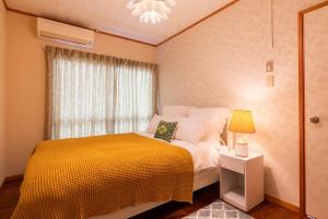 沖縄市にあるNew open American Village Sunset beach TLA&TDYのベッドルーム1室(黄色い毛布と窓付)
