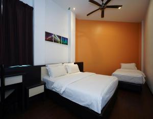 a bedroom with two beds and a ceiling fan at Aurora Boutique Hotel in Bahau