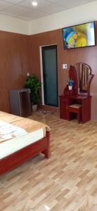1 dormitorio con 1 cama y TV en la pared en Bana Home & Spa en Hoi An