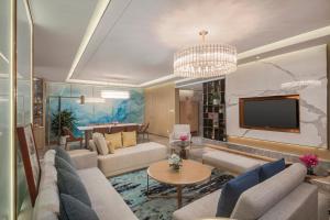 a living room with couches and a flat screen tv at Holiday Inn Express Zhengzhou Longzi Lake by IHG in Yaoqiao