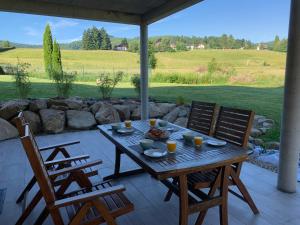 een houten tafel met 2 stoelen op een patio bij Gîte au cours d’eau in Le Hohwald