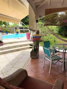 a patio with a table and chairs and a pool at Studio avec piscine partagee jardin clos et wifi a Les Abymes in Les Abymes