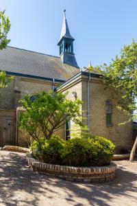 a large brick building with a tower on top of it at Stella Maris in Oudeschild