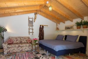 a bedroom with a bed and a couch at Stella Maris in Oudeschild
