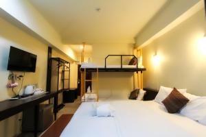 a bedroom with a bed and a bunk bed at Baan Pordeedin in Chiang Rai