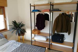 a room with a bed and a rack of clothes at ZRM center in Idrija