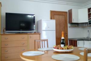 a kitchen with a table with a bottle of wine and fruit on it at ZRM center in Idrija
