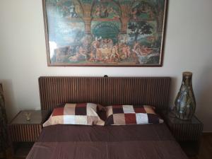 Ce lit se trouve dans un dortoir orné d'une peinture murale. dans l'établissement George's Apartment, à Athènes