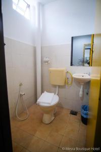 a bathroom with a toilet and a sink at Mesra Boutique Hotel in Port Dickson