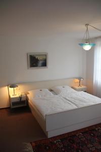 een slaapkamer met een wit bed en 2 lampen bij Hotel Linde Leutkirch in Leutkirch im Allgäu