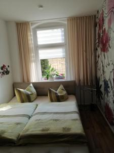 twee bedden in een kamer met een raam bij USIS_FERIENWOHNUNG im Harz in Quedlinburg