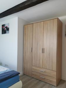 a bedroom with a large wooden cabinet next to a bed at Susan's ole Schoolhus in Fehmarn