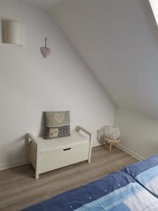 a bedroom with a white bed and a white dresser at Susan's ole Schoolhus in Fehmarn