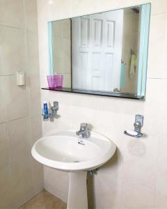 y baño con lavabo y espejo. en Haeansung Pension, en Seogwipo