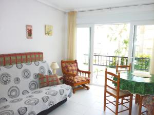 a bedroom with a bed and a table and a balcony at The cozy apartment in Torrevieja