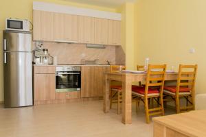 a kitchen with a table and chairs and a refrigerator at Апартамент и студио Фантазия in Sozopol