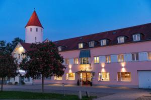 un grand bâtiment blanc avec un toit rouge dans l'établissement Hotel Am Turm, à Kaufbeuren