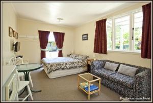 a bedroom with a bed and a couch and a table at The Station House Motel in Collingwood