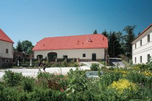 twee mensen die door een tuin lopen voor een gebouw bij Gościniec Pod Gruszą in Świerzawa