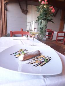 einen Teller mit Essen auf einem Tisch mit einem Glas Wein in der Unterkunft Locanda Merlaschio in Faenza