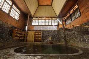 uma grande piscina de água num edifício com janelas em Fujisan Ryokan em Hanamaki