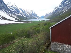 a red barn in front of a snow covered mountain at Lunde Turiststasjon in Skei