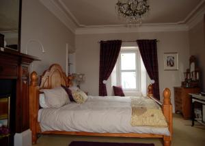 ein Schlafzimmer mit einem großen Bett und einem Fenster in der Unterkunft Orsay House in Portnahaven
