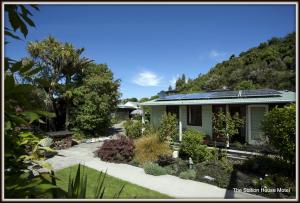 a house with a garden in front of a mountain at The Station House Motel in Collingwood