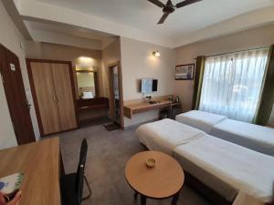 Postel nebo postele na pokoji v ubytování Hotel Gulmohar Grand