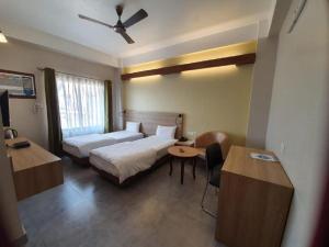 Postel nebo postele na pokoji v ubytování Hotel Gulmohar Grand