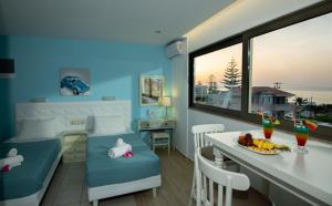 a room with a table and chairs and a dining room at Kastro Beach Apartments in Malia