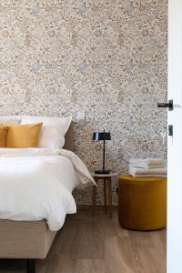 1 dormitorio con cama y papel pintado con motivos florales en Elvier B&B, en Mol