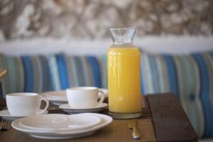 a bottle of orange juice sitting on a table with two cups at Villa Del Mar in Vasiliki