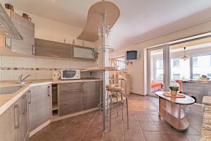 a kitchen with stainless steel appliances and a table at SR Apartamentai in Druskininkai