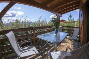a patio with a table and chairs on a balcony at Chalets de CEMMA in Evisa