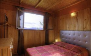 a bedroom with a bed and a window at Chalets de CEMMA in Evisa