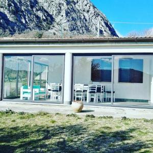 a house with glass doors and a table and chairs at B&B La Montagna Rosa in Castelnuovo