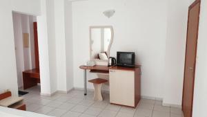 a room with a desk with a mirror and a television at Майстор Костадин - 1878 in Obzor