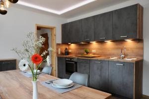 a kitchen with a wooden table with a vase of flowers at Ferienwohnung "Liftblick 1" im Kurort Altenberg in Kurort Altenberg