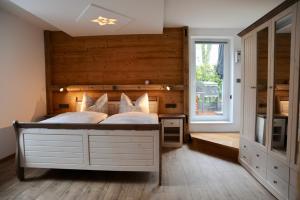a bedroom with a large bed with a wooden wall at Ferienwohnung "Liftblick 1" im Kurort Altenberg in Kurort Altenberg