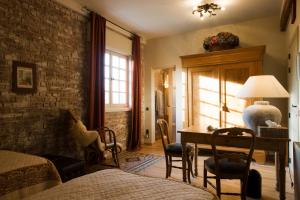 a bedroom with a bed and a desk and a table at B&B Willow Lodge in De Pinte