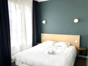 een slaapkamer met een groot wit bed en een raam bij Hotel Saint Louis in Brest