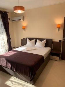 a bedroom with a large bed with white sheets at Vila Ando Mamaia Nord in Mamaia Sat/Năvodari