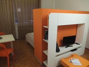 a room with a bed with a tv in it at #iRicci3stanze in Monfalcone