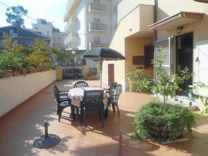 patio con tavolo, sedie e ombrellone di Villino Di Girolamo a Pineto
