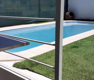 a view of a swimming pool from inside a house at Bem Me Quer in Almada