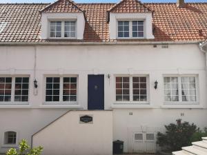 a white house with a blue door at Gîte les Hortensias in Marquise +24 photos
