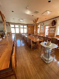 een eetkamer met houten tafels en stoelen bij Tengudaira Mountain Lodge in Tateyama