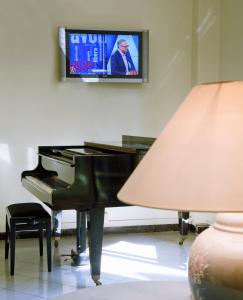 un soggiorno con pianoforte e TV di Hotel Quisisana a Rimini